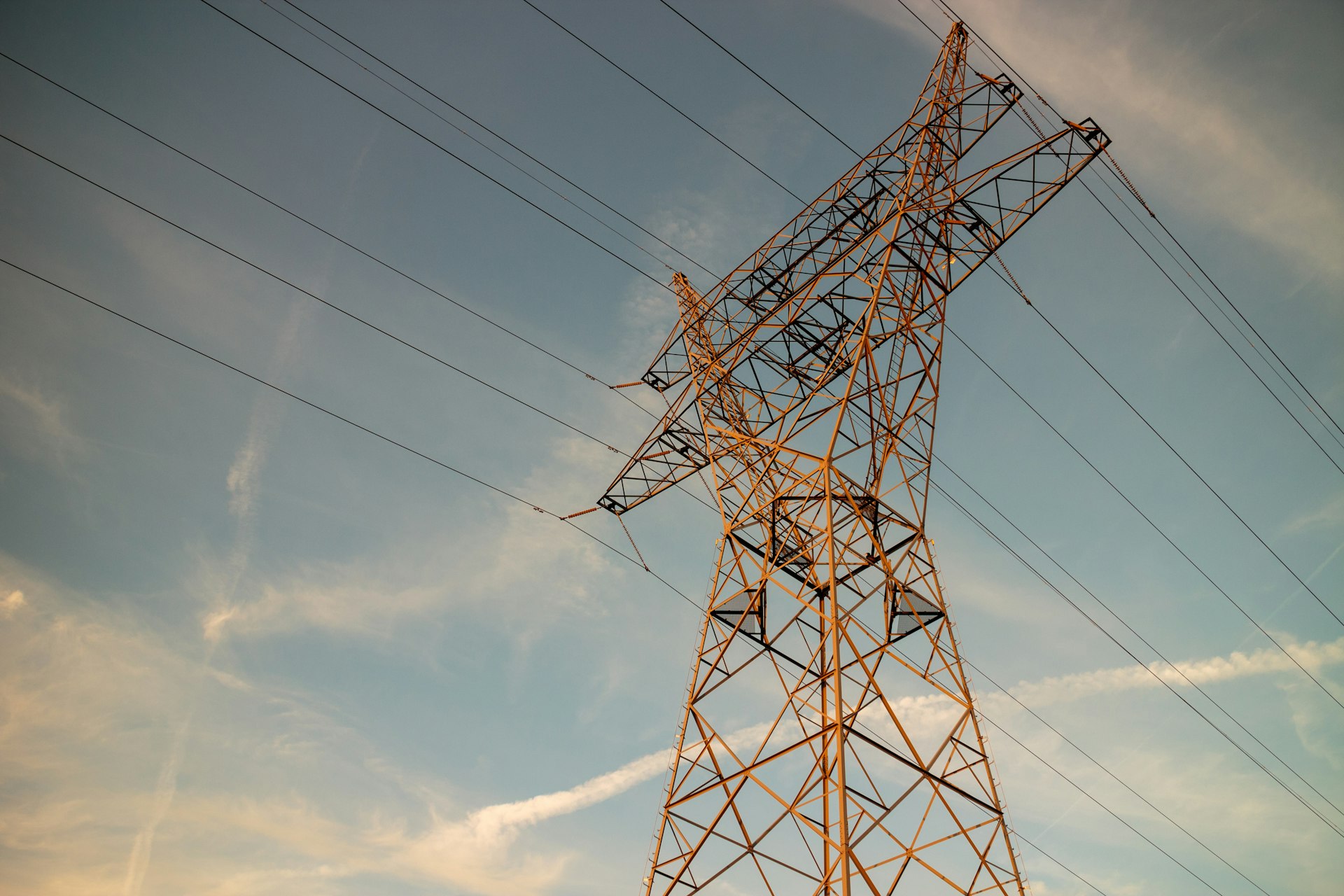 a high voltage power line against a blue sky